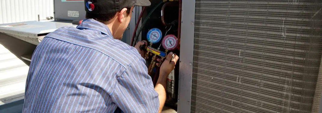 HVAC technician servicing a condenser unit in Round Rock