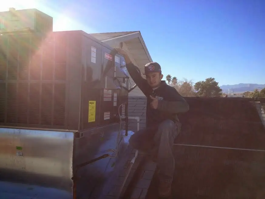 HVAC technician performing Heat Pump Repair on a rooftop unit in Round Rock
